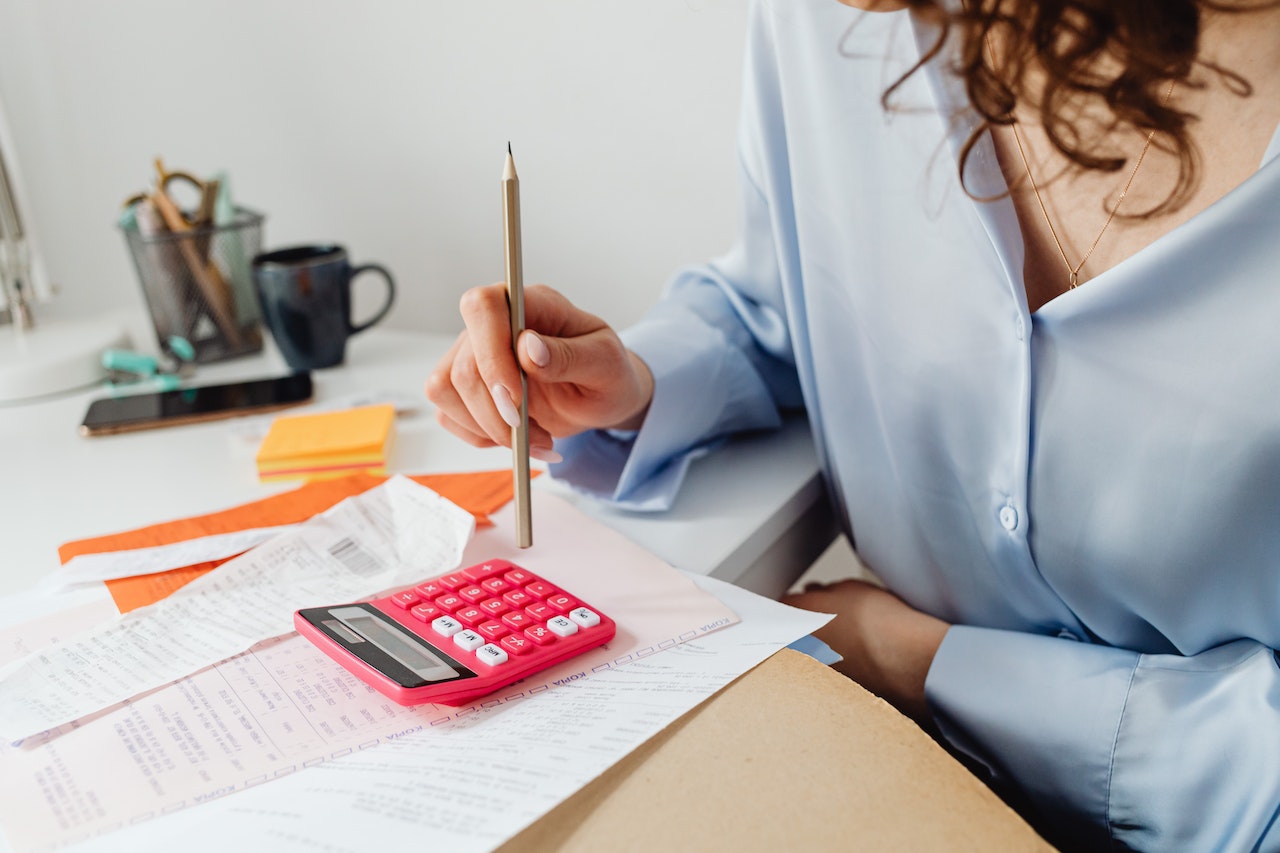 Una mujer con una factura con descuento y una calculadora y un lápiz
